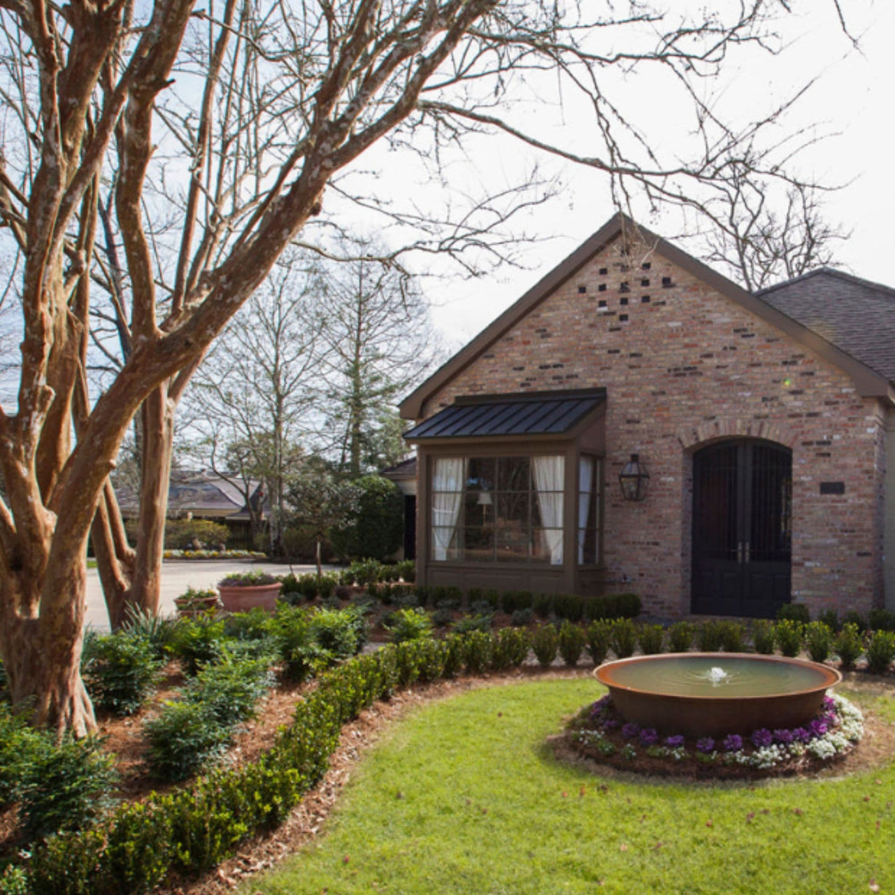 Sugar Kettle Cast Iron Fountain On Beautiful Garden With Trees  And A House