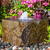 Tamaishi Stone Garden Fountain With Colorful Plants And Flowers Background