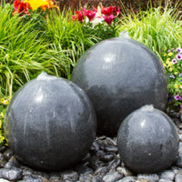 Thumbnail for Triple Black Granite Stone Sphere Fountain With A Varity Of Plants In The Background