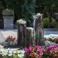 Thumbnail for Triple Rustic Basalt Stone Outdoor Fountain Surrounded By Flowers With Trees Background