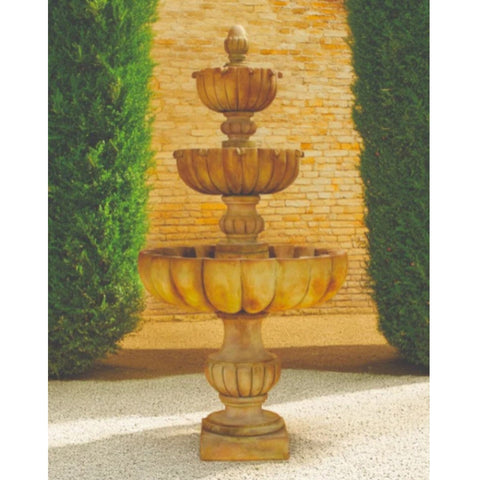 Urbino Grande Three Tier Pond Fountain With Tall Green Hedges And Brick Wall In The Background