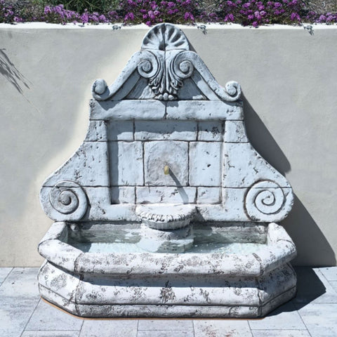 Versailles Wall Fountain With Cemented Wall And Flowers In The Background