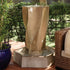 Thumbnail for Vortex Outdoor Water Fountain By Gist Besides Rattan Sofa With Green Plants Behind