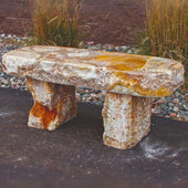 Yellow Onyx Garden Bench Near Brown Wall With Pebbles And Tall Grasses