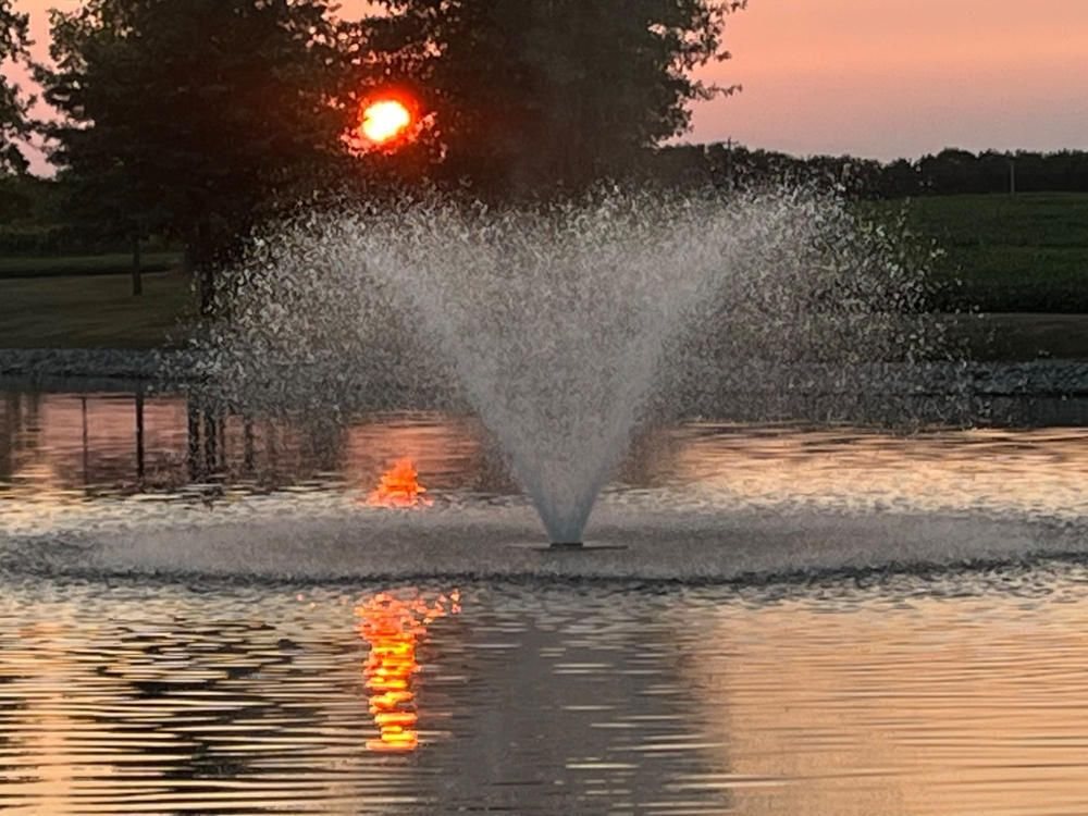Pond fountain at sunset